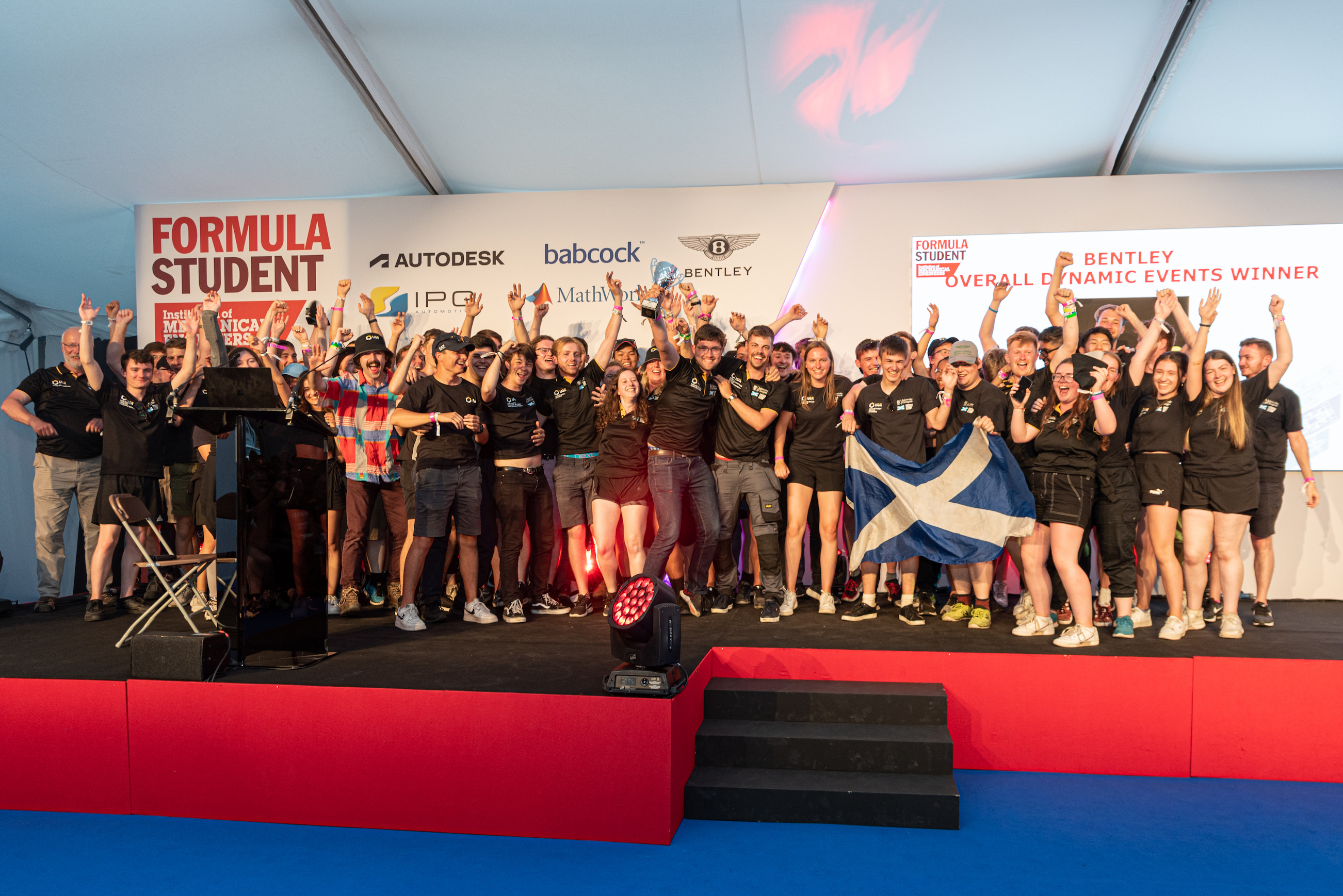 The UGRacing team celebrate their win onstage at the finals of the 2022 Formula Student competition