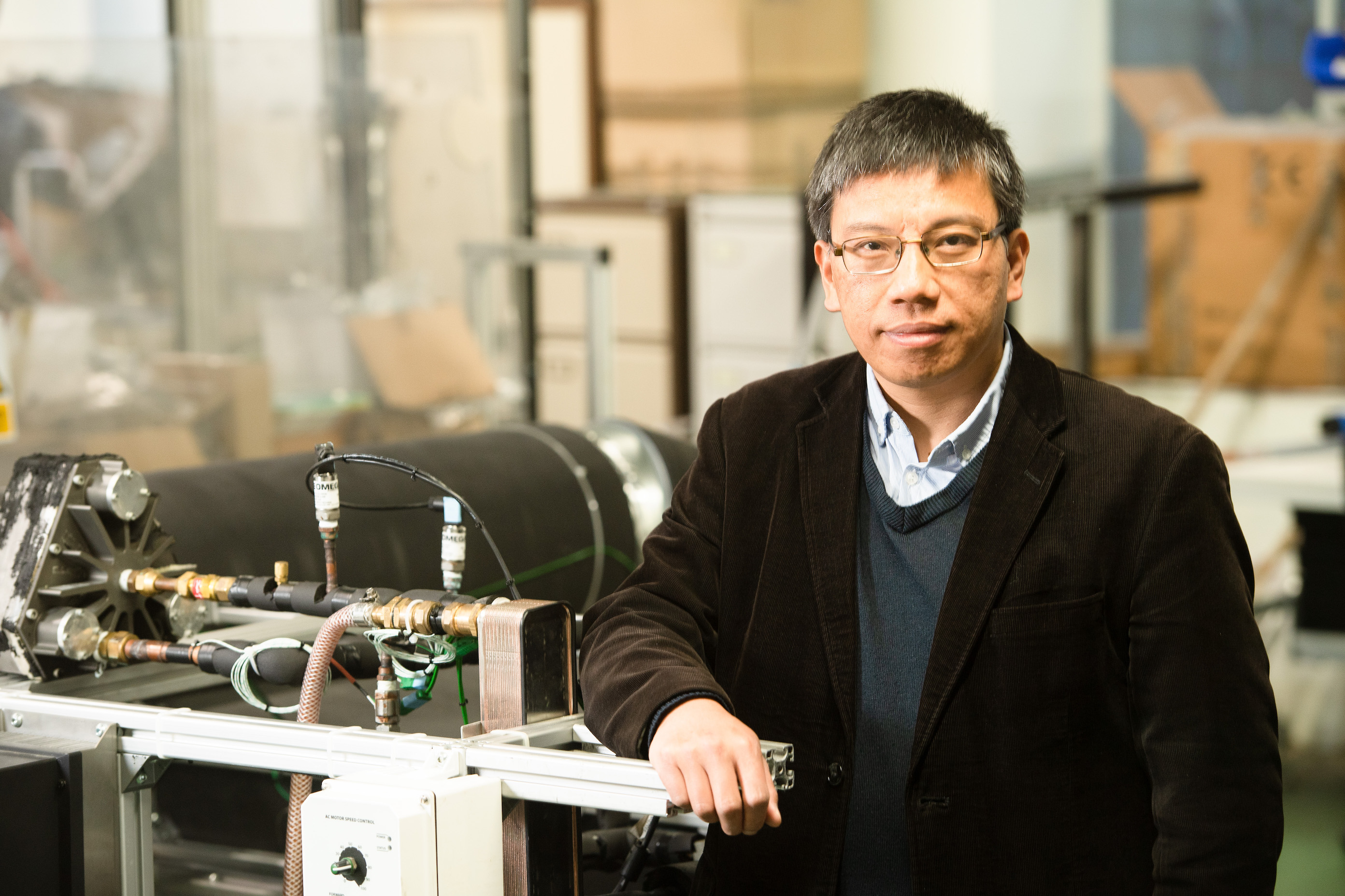 A photo of Professor Zhibin Yu with his prototype flexible heat pump technology