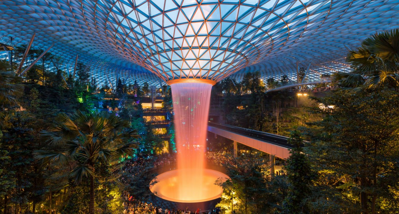 Glass roof and indoor water feature of Jewel Changi lit up at night [Photo: Shutterstock]