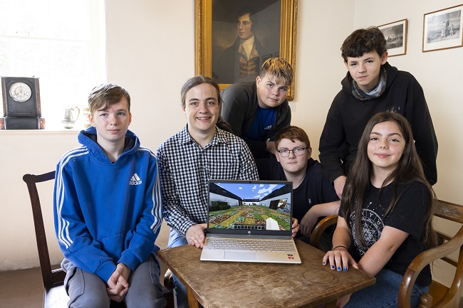 Group photo of local school children from Dumfries testing the new Minecraft Ellisland app with Bailey Hodgson, the University of Glasgow Minecraft Society’s President Left to right Jamie Hardie, 15; Bailey Hodgson, the University of Glasgow Minecraft Society’s President; Max Hardie, 13, Ryan Hannah, 15; Charlie Keenan, 13, and Rhona Keenan 11. Photo Credit Martin Shields