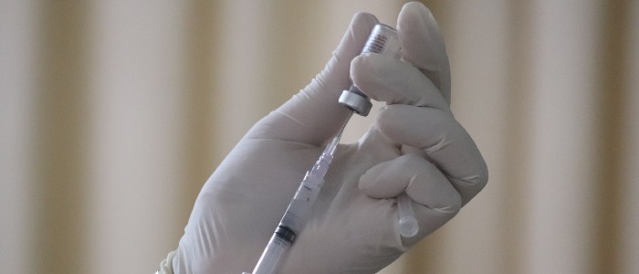 a hand preparing a vaccination needle
