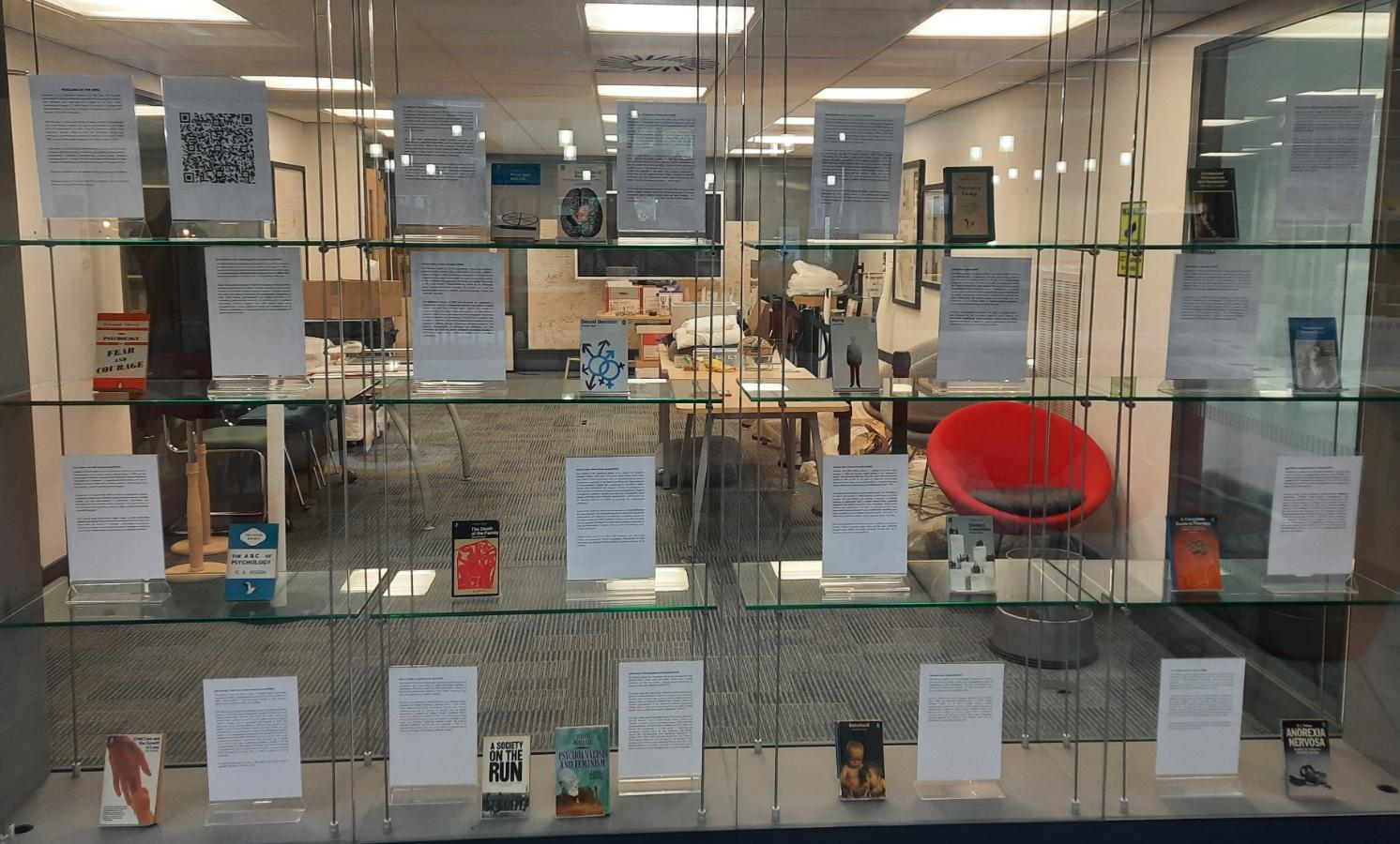 Photograph of physical exhibition. Book covers in glass display.