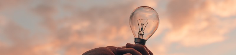 a hand holding up a lightbulb