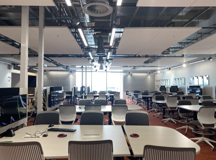 Flat floored teaching room with tables and chairs.