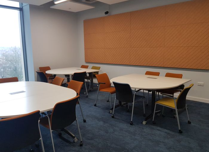 Flat floored teaching room with tables and chairs.