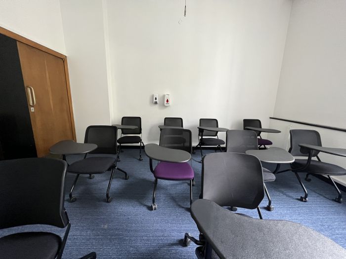 Flat floored teaching room with tablet chairs.