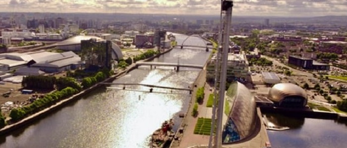 Looking down from above on the River Clyde at sunset showing two bridges, the Science Centre and the city in the distance
