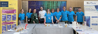 A group of people from the Living Lab, BioClavis and Polyomics standing around tables with an activity from the ARCadia festival 