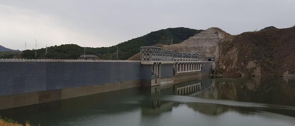 A dam is built across a river, forming a basin of water behind it