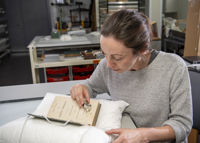 Keira McKee, a UofG Book Conservator examines the rare 