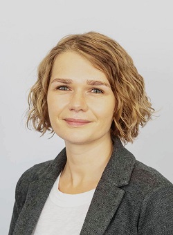 Women with chin length blonde hair smiling at the camera