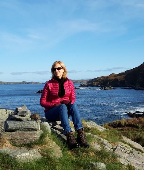 Lecturer Susan Finlay sitting on a top of a hill in Scotland