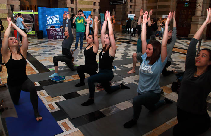 Photograph showing a group of people doing a yoga pose. 