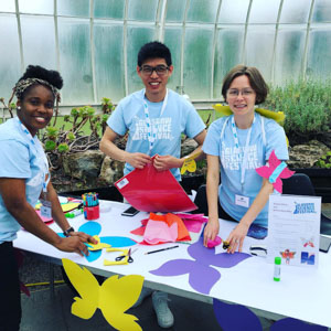 Photograph showing 3 GSF in Action interns with colourful paper butterflies. 