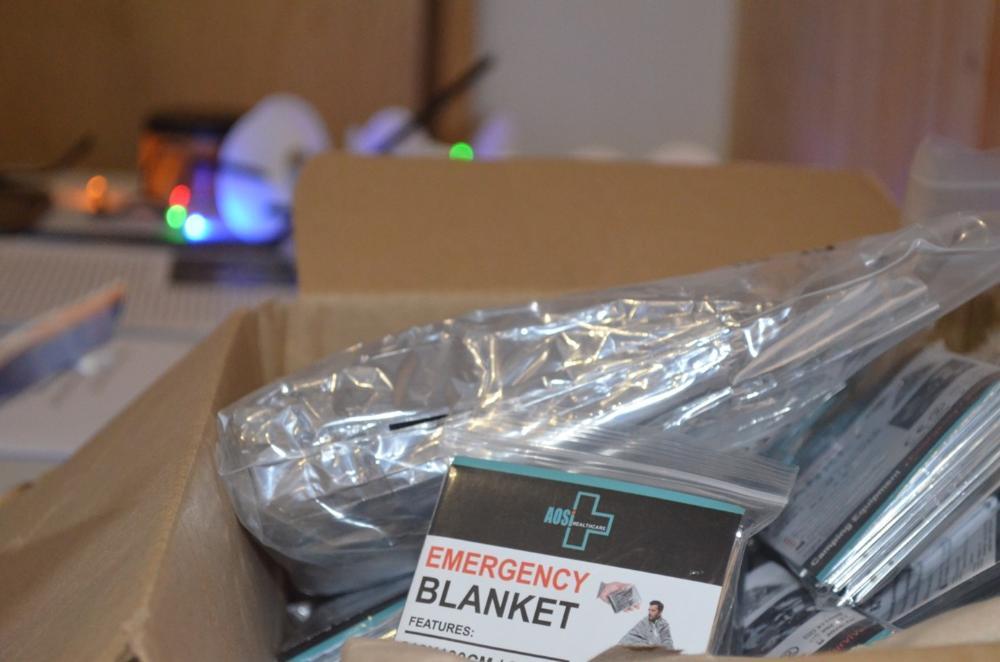 An up-close photo of silver reflective emergency blankets in a box.