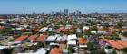 View of the low red roofs of surburban homes with skyscrapers in the distance in the city of Perth in Western Australia. Source: chameleonseye https://www.istockphoto.com/photo/aerial-landscape-view-of-perth-western-australia-gm1289818542-385380862
