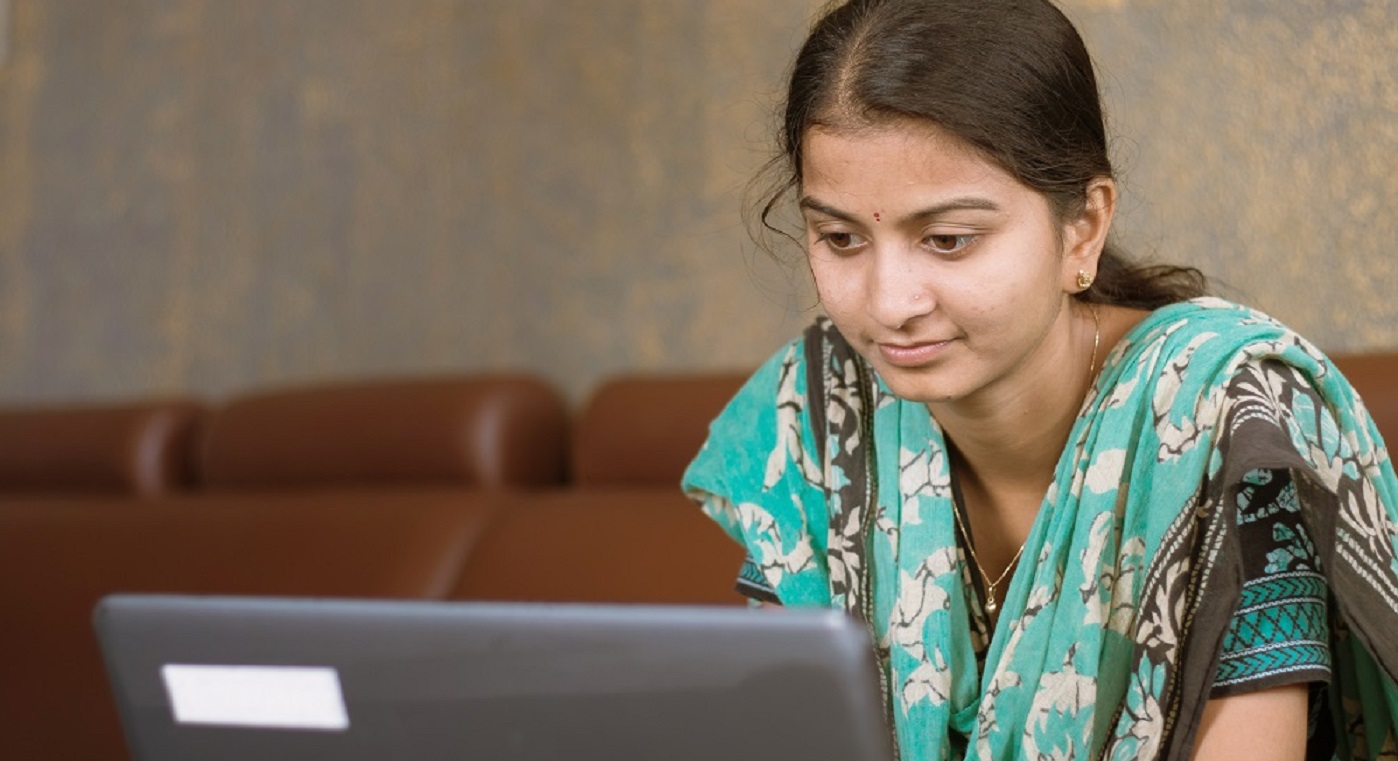 Smiling indian woman in casual dress using a laptop at home. Source: lakshmiprasad S | iStockphoto https://www.istockphoto.com/photo/smiling-indian-girl-student-or-employee-busy-on-laptop-sit-at-home-in-casual-dress-gm1224341575-359960317