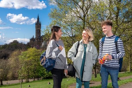 University of Glasgow students in Kelvingrove Park with a view of the Gilbert Scott building and tower