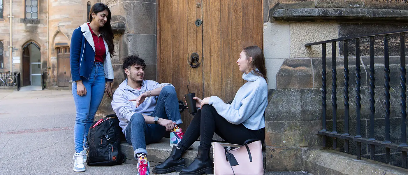 Three students in doorway chatting