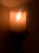 a blurry shot of a candle up close in the dark