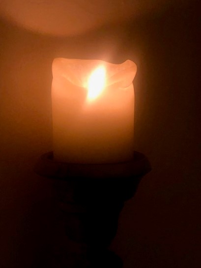 a blurry shot of a candle up close in the dark