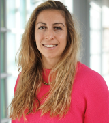 A head and shoulders shot of Dr Aurelie Najm wearing a pink sweater