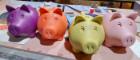 Photo of four brightly coloured piggy banks