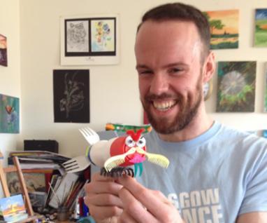 Photograph of a member of the GSF team holding a litterbug creation. 