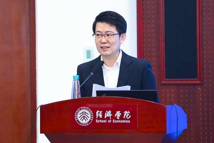 A man at a podium with Chinese characters and words 'School of Economics' on it. Source: Peking University