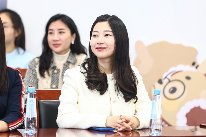Two young women seated at desks paying attention to a speaker: Source Peking University