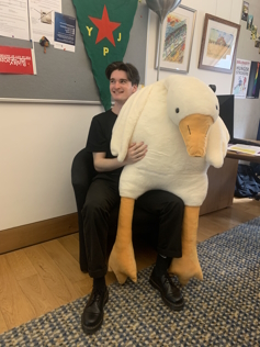 Young male with a 6 foot cuddly goose toy on his lap