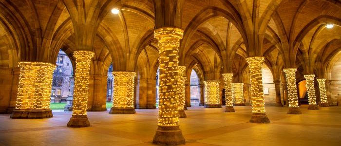 Arches of the cloisters and pillars decorated with fairy lights wrapped around them