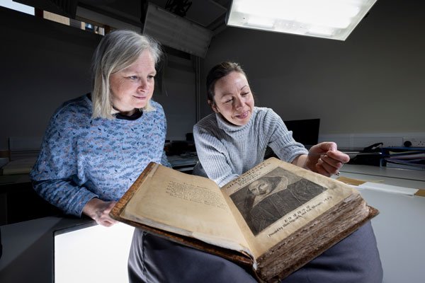 Two women looking at a copy of Shakespeare's First Folio