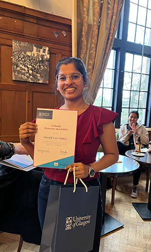 Praneetha proudly holding her certificate of distinction