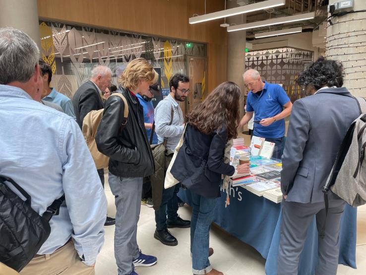 Group of people looking at a table filled with books of Adam Smith. Source: Claire Martin College of Social Sciences