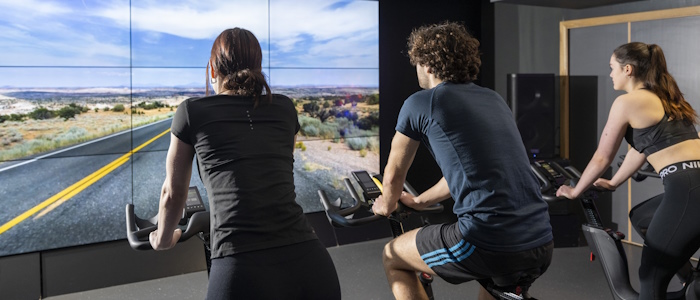 Students exercising on revolve indoor bicycles