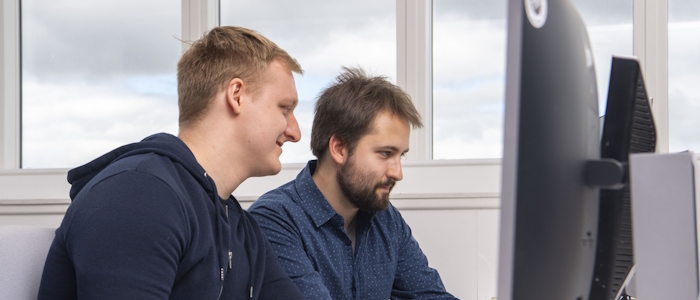 Two students looking at a monitor in computing class