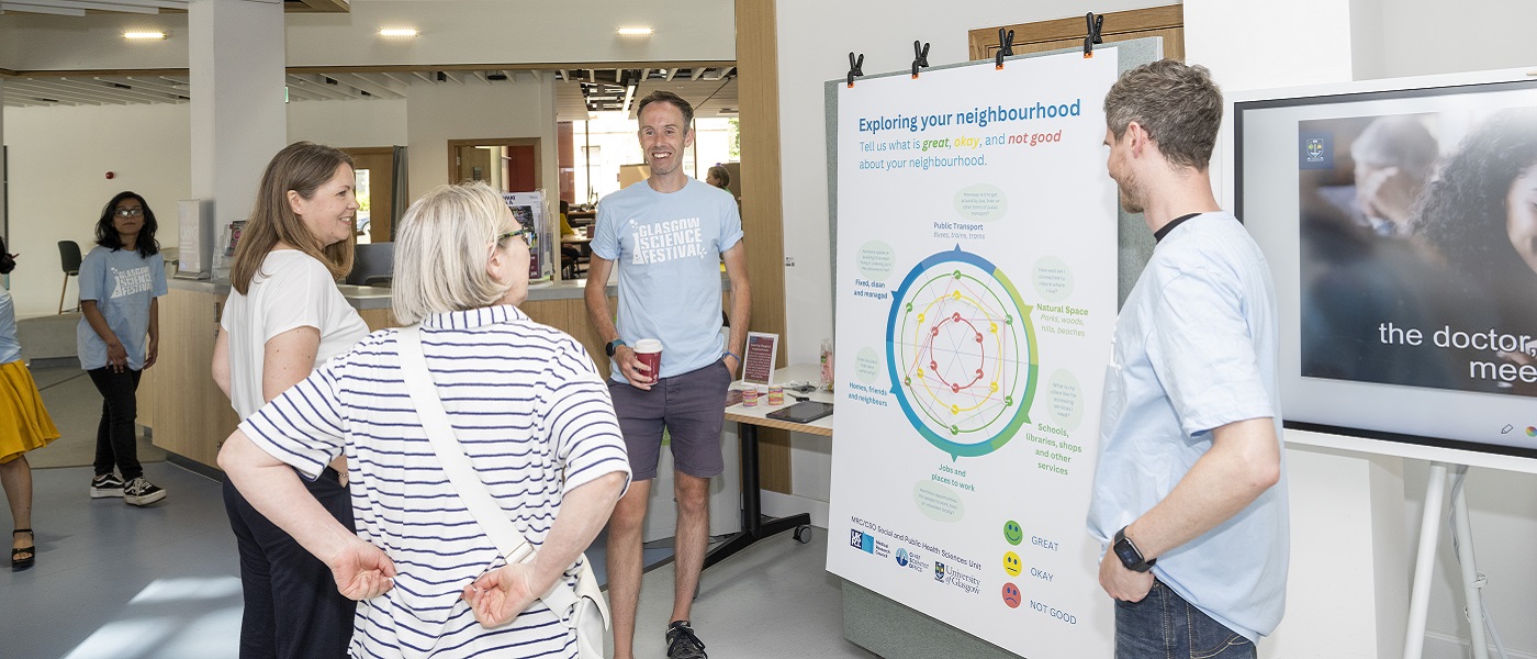 Photo of attendees at the Byres Community Hub community day in June 2023 viewing posters