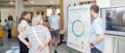 Photo of staff and visitors viewing a poster at the Clarice Pears community day in June 2023