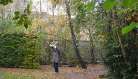 A study participant stands below autumnal trees. 