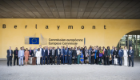 A group of dignitaries stood in front of a yellow wall and an EU Commission logo