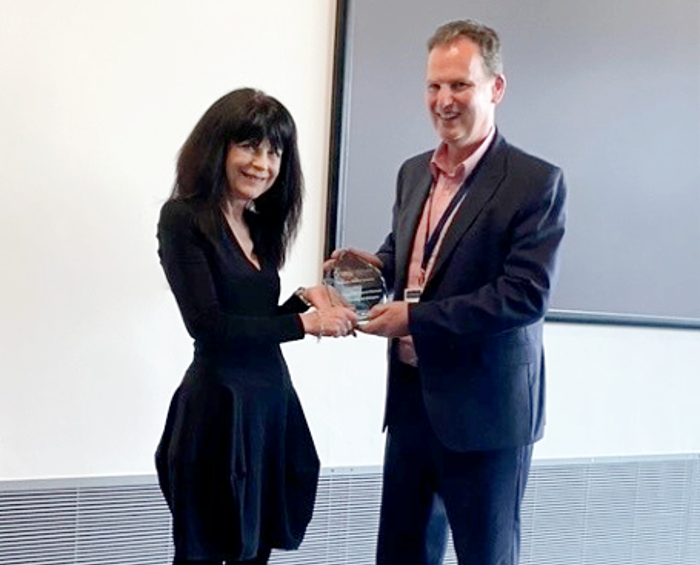 Professor Maggie Harnett receives her Tenovus medal from Professor Ian McInnes