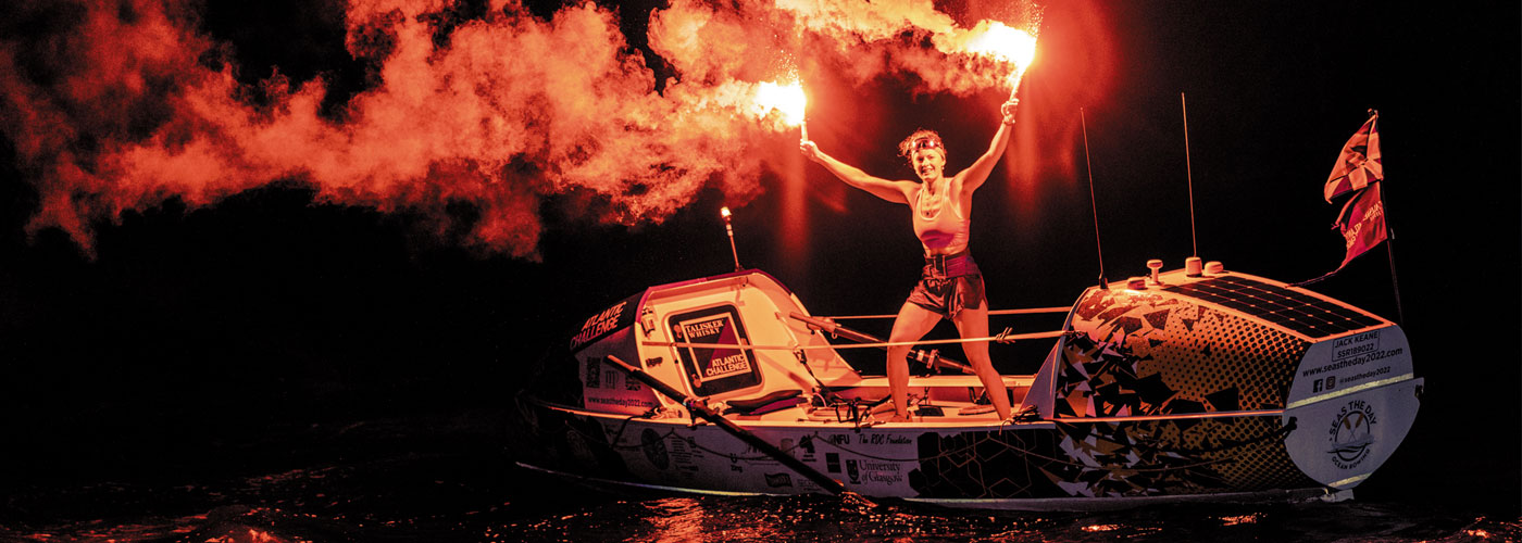 Miriam Payne standing on boat with flares
