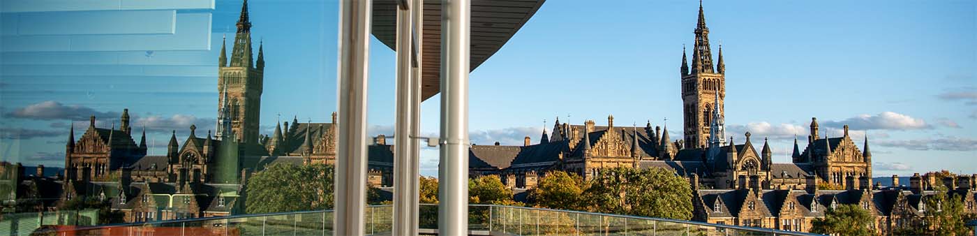 The Gilbert Scott Building photographed from the balcony of the James McCune Smith Learning Hub. The Gilbert Scott Building is reflected in the windows of the JMS Building.