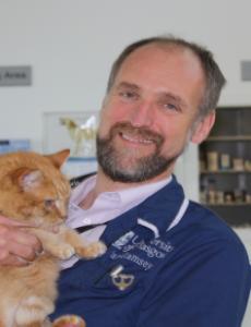 Headshot image of Ian Ramsay holding a cat