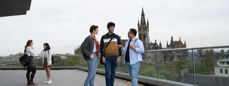 Three students standing on the viewing platform of the JMS. The Gilmorehill tower can be seen in the background.