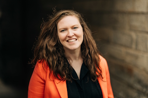 A headshot of Gemma Milne, smiling towards the camera