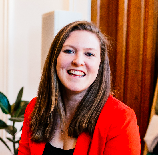 woman with brown hair wearing red blazer