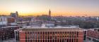 Glasgow University gothic tower and the modern ARC building seen aginst a sunset