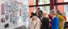 An image of people viewing the Byres Community Hub Photovoice at the launch